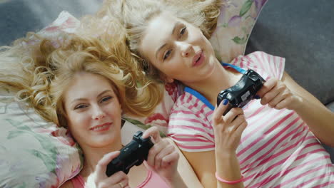 two young female friends playing on the computer console 2