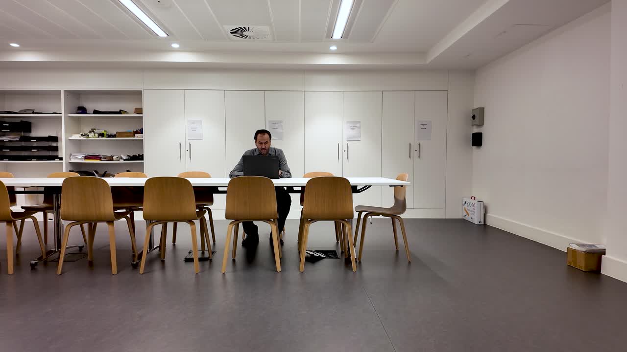 Layoffs And Corporate Downsizing South Asian Male Alone In Empty Office Working At Table