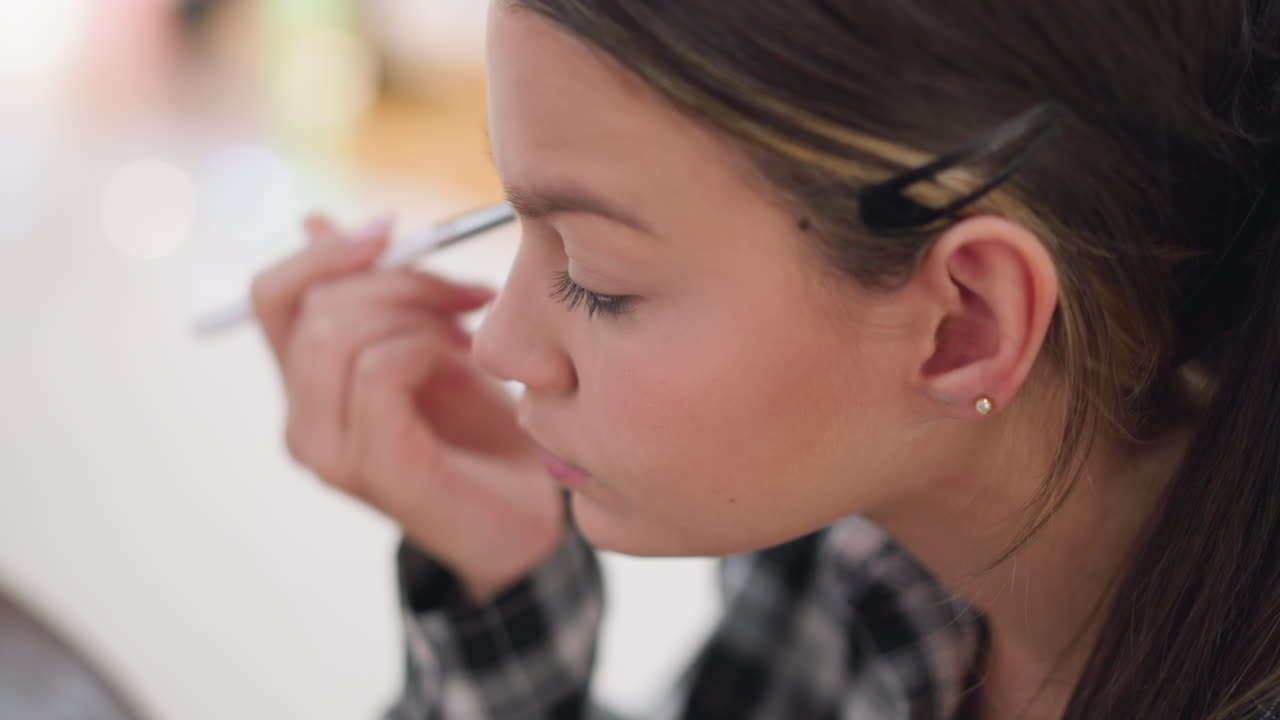 primer plano de una mujer arreglando el maquillaje en su cara con un pincel, centrado en la aplicación de polvo alrededor del área de los ojos, ella aplica suavemente maquillaje para mejorar las características faciales, asegurando un acabado suave