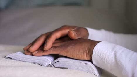 man praying to god with hands together with bible caribbean man praying with white background stock footage