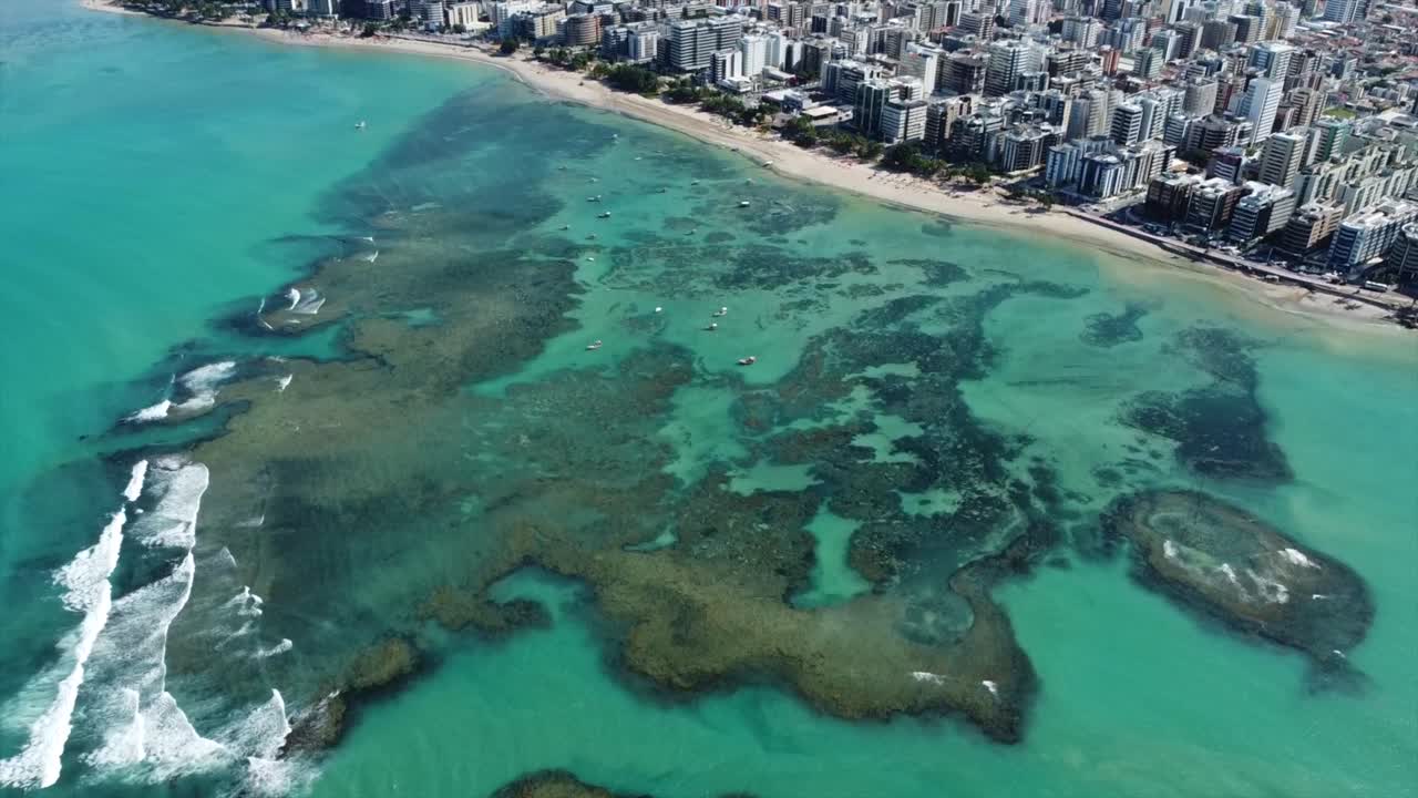 hermosos arrecifes de colores desde arriba y ciudad de maceio, viajes + rascacielos