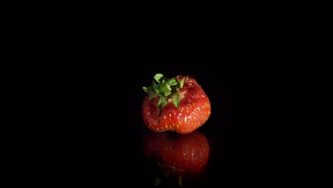 close-up rotation red ugly crumpled, bitten strawberry, copy space.