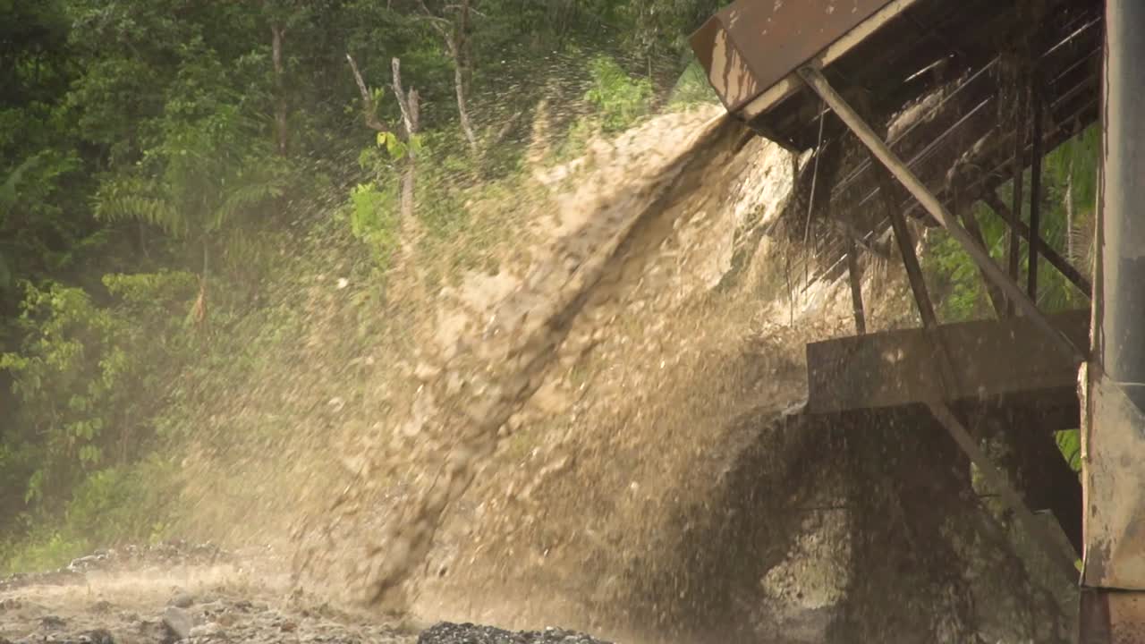 Processed sand and mud spewing out of a gold dredger in to the river in Checo, Colombia-1