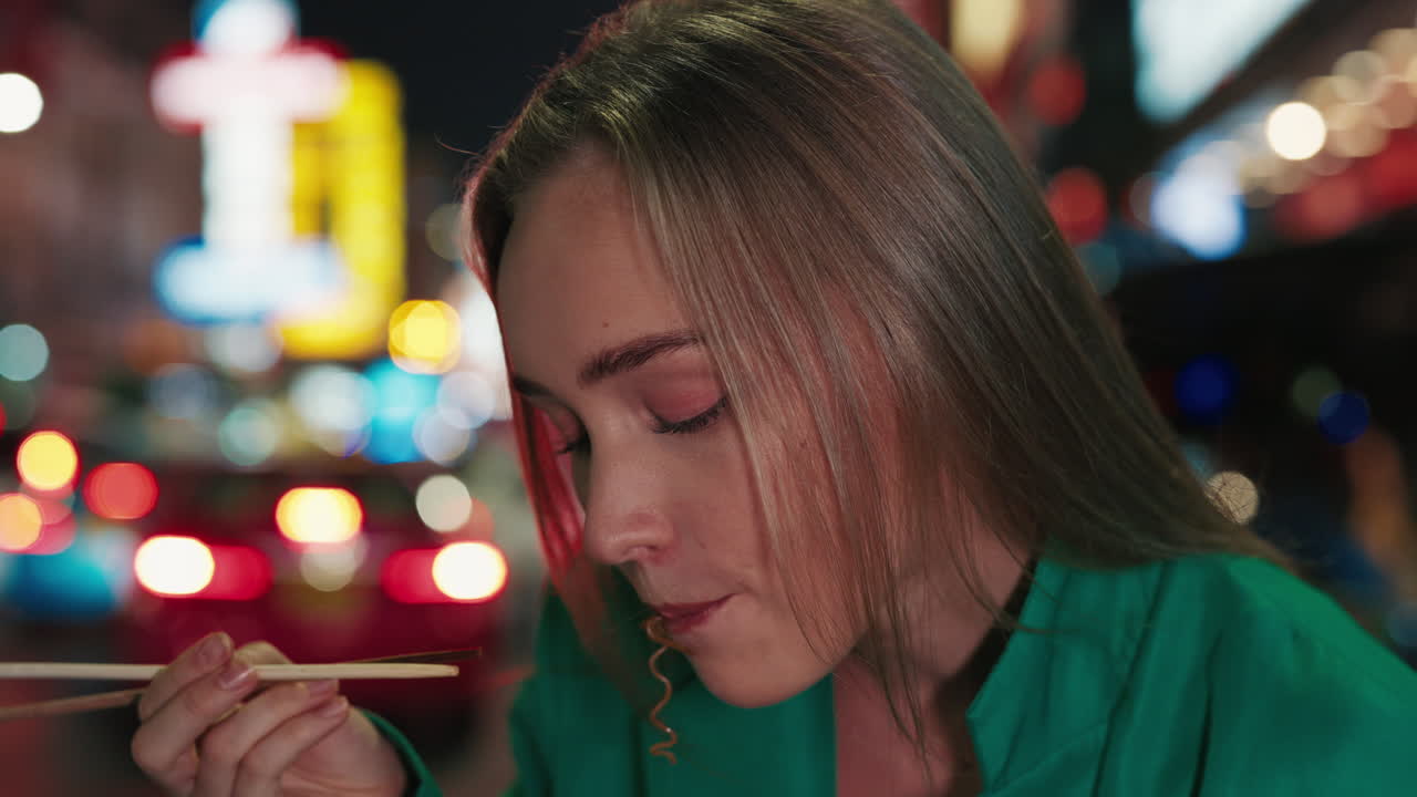 Woman Eating Noodles at a Night Market