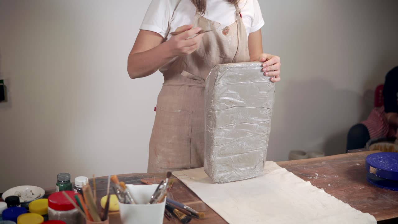 mujer esculpiendo arcilla