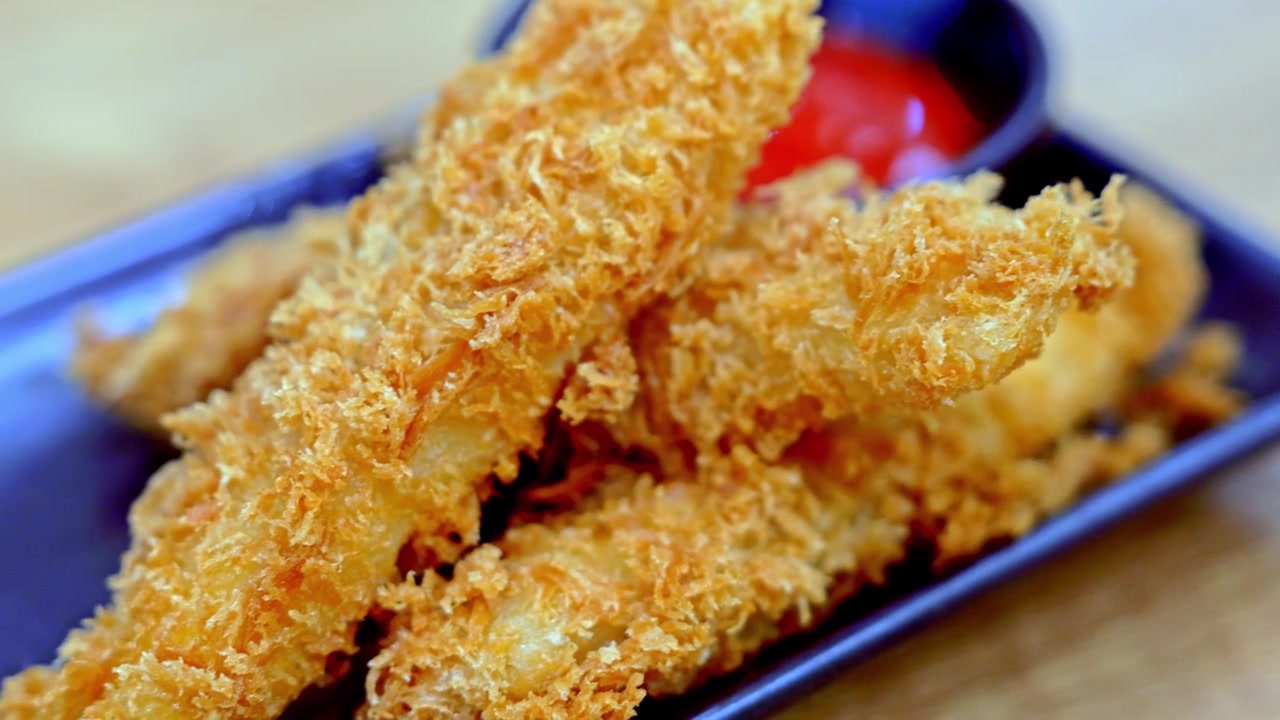 Close-up of golden crispy fried cheese sticks served with rich tomato dipping sauce, showcasing crunchy coating and melted cheesy texture.