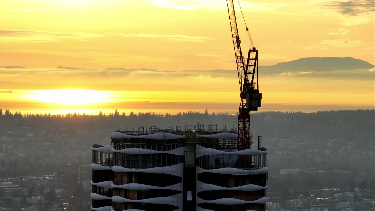 vista aérea de una grúa torre en un edificio de gran altura en construcción al atardecer en vancouver, canadá