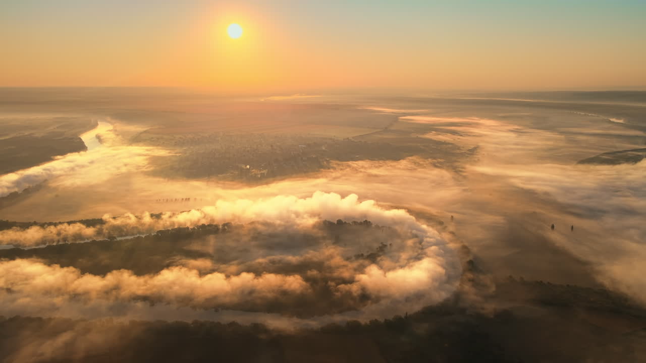 Aerial drone view of nature of Moldova at sunset. River and lush fog above it, village, greenery