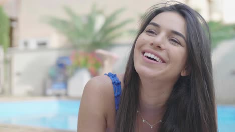 bonita hermosa mujer sonriendo junto a la piscina en un hotel de lujo