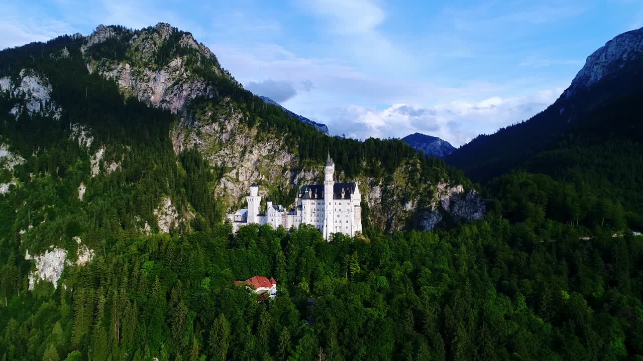 The iconic Neuschwanstein Castle stands proudly amid lush forests and mountains
