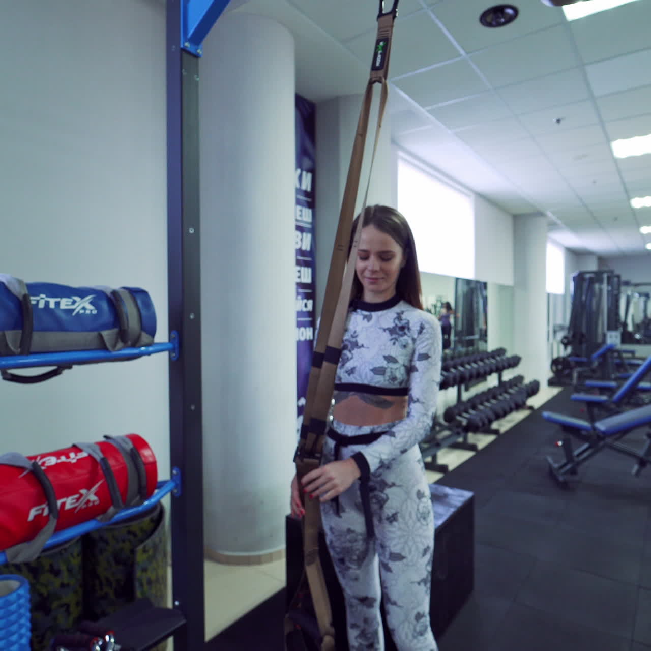 Spacious light gym for fitness training with sporty people doing workout indoors. Active women and men trains their muscles in the sports centre with modern equipment.