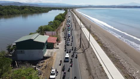 caravan of motorcyclists on tour driving by the sea