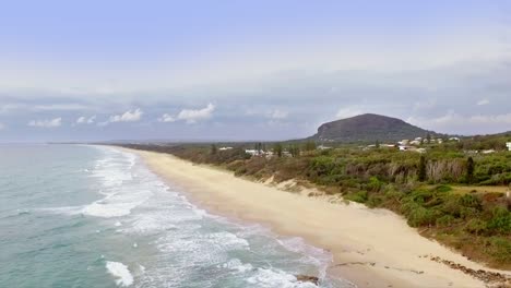 toma aérea de drones en movimiento lento mirando al sur a lo largo de la costa hacia el monte coolum