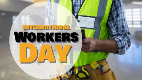 Animation-of-international-workers-day-text-over-caucasian-male-worker-using-tablet