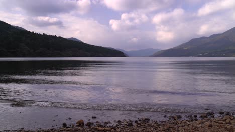 view out on lake with ripples and beautiful clouds on perfect day - low angle