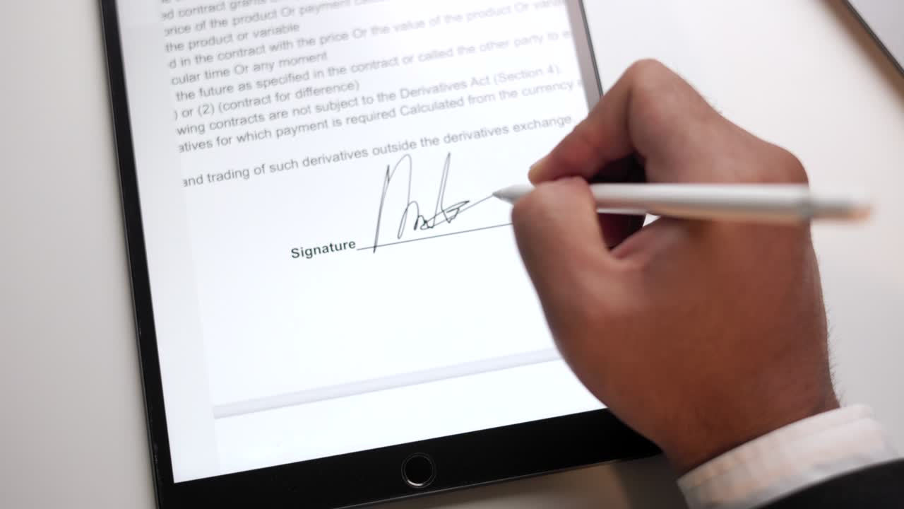 Close up businessman hand working electronic Signature on Tablet by Stylus at night. Write business agreement of contract. Man signing contract on tablet. Business and technology concept.