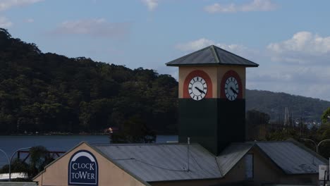 old clock tower timelapse in rural town by a lake and mountain