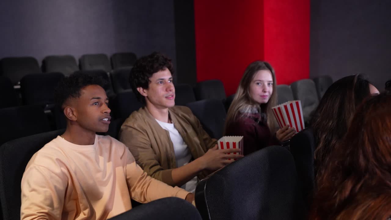 Amici che si godono un film al cinema