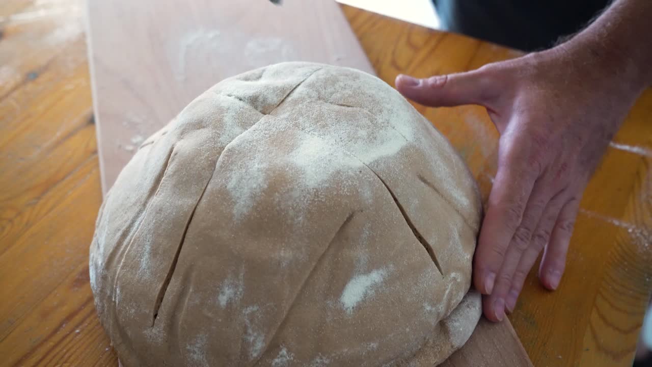 Baker scoring dough before baking bread