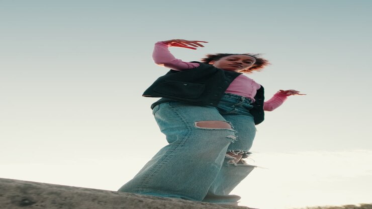 Young Woman Dances Barefoot on Rooftop at Sunset
