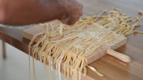maestría en pasta: video en cámara lenta de primer plano de la clasificación individual de tagliatelle por parte del chef - técnica de harina - 4k