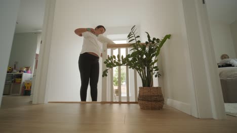 a beautiful pregnant woman tidying her home, engaged in household chores. the scene captures domestic life, maternity, and the balance of routine and preparation during pregnancy