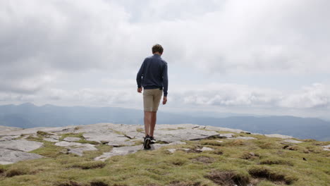 man celebrating on mountain summit