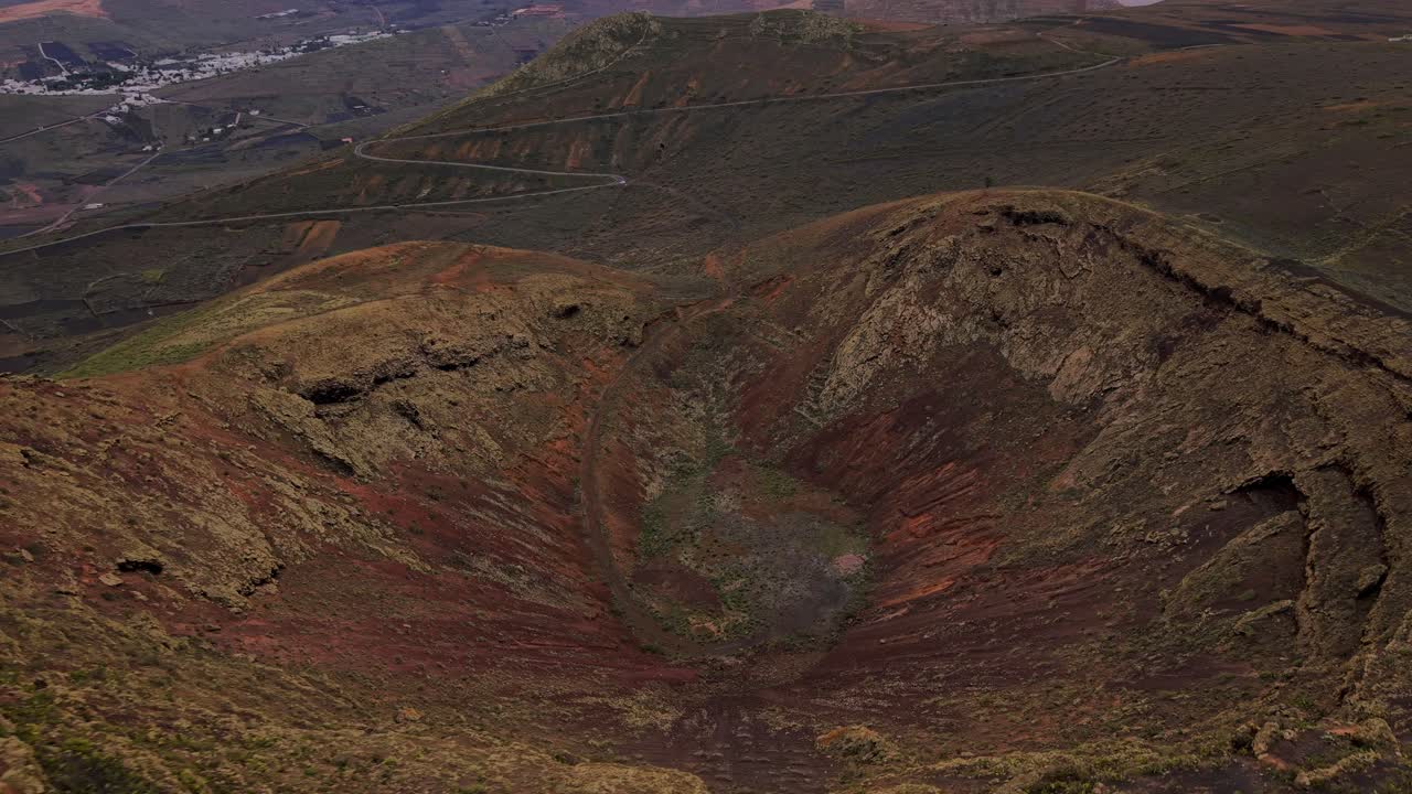 Lanzarote's barren volcanic landscape with a large caldera seen from an aerial perspective