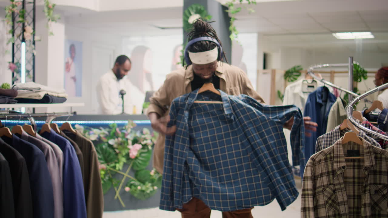 hombre mirando de cerca los blazers en el centro comercial