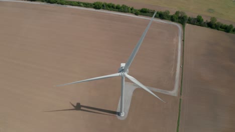 aerial view from drone looking down on windmill blades rotating slowly generating clean renewable electricity