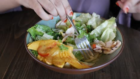 woman eating a mango chicken salad