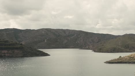 Aerial-wide-shot-of-tranquil-portuguese-lake-during-cloudy-day-after-sunset