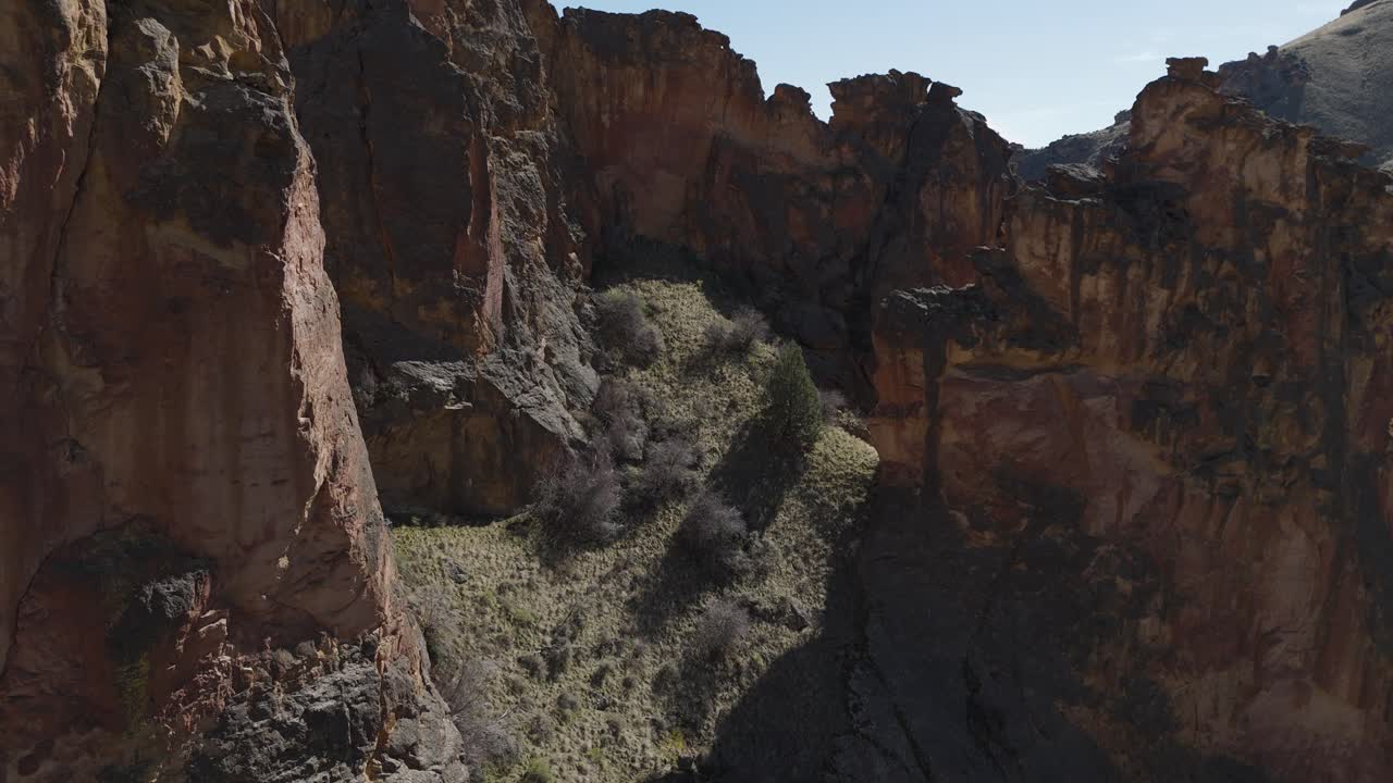 Drone langsomt stiger op gennem klippeformationer ved Leslie Gulch Oregon for at afsløre en snoet grusvej