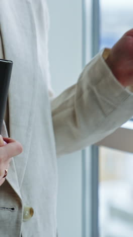 woman holding a notebook by a window