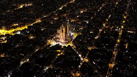 aerial view of barcelona eixample residential district and famous basilica sagrada familia at night. catalonia, spain