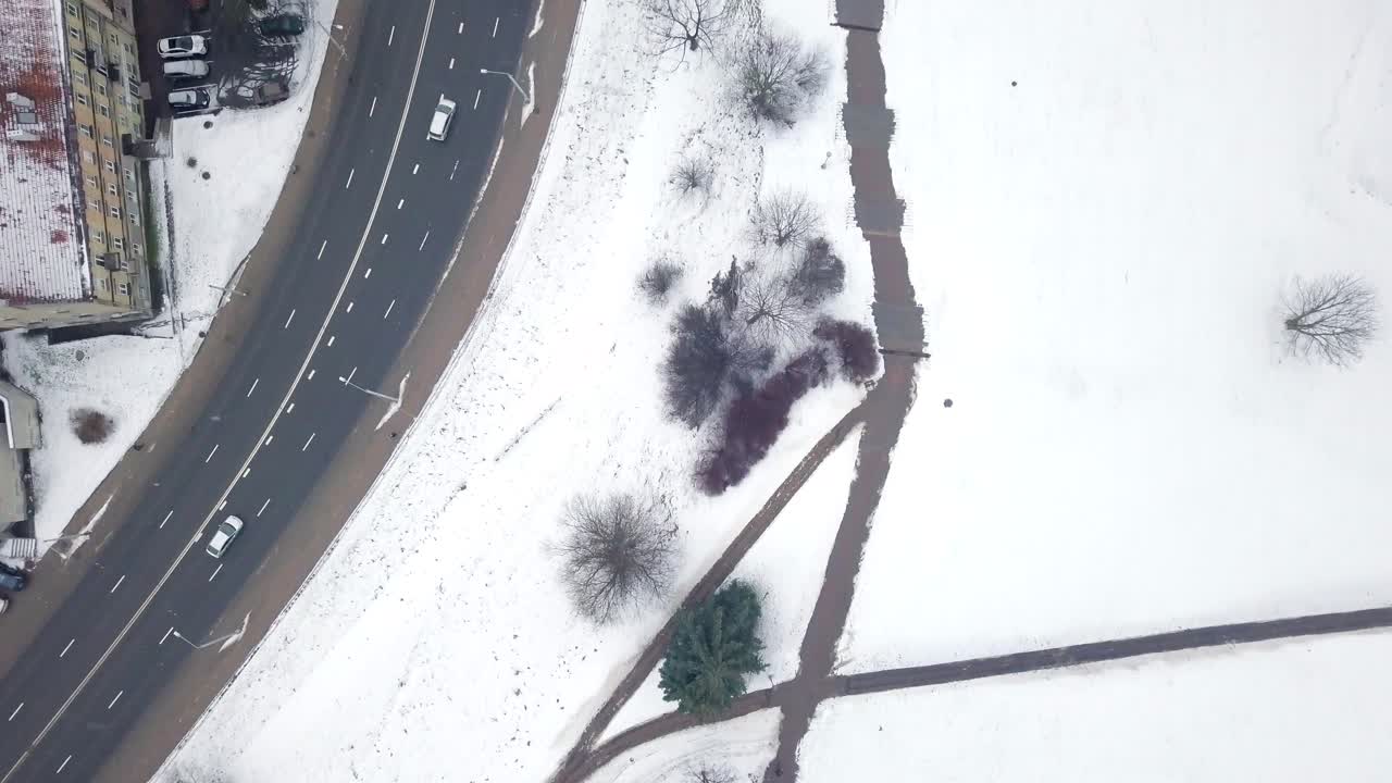 눈으로 뒤덮인 공원 옆 도시 거리 위의 공중 촬영