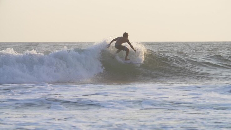 Tracking Shot of a Man Surfing a Wave