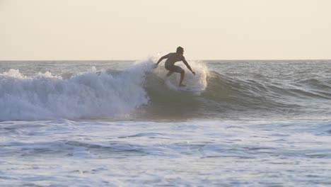 tracking shot of a man surfing a wave