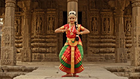 young indian classical dancer in traditional attire posing at an ancient temple