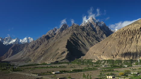 Toma-Cinematográfica-De-Drones-Del-Pico-Tupopdan,-Conos-De-Passu-En-Hunza-Pakistán-Picos-Montañosos-Cubiertos-De-Nieve-Con-Acantilados-Escarpados,-Amplia-Toma-Aérea-Panorámica-Para-Revelar-La-Cordillera