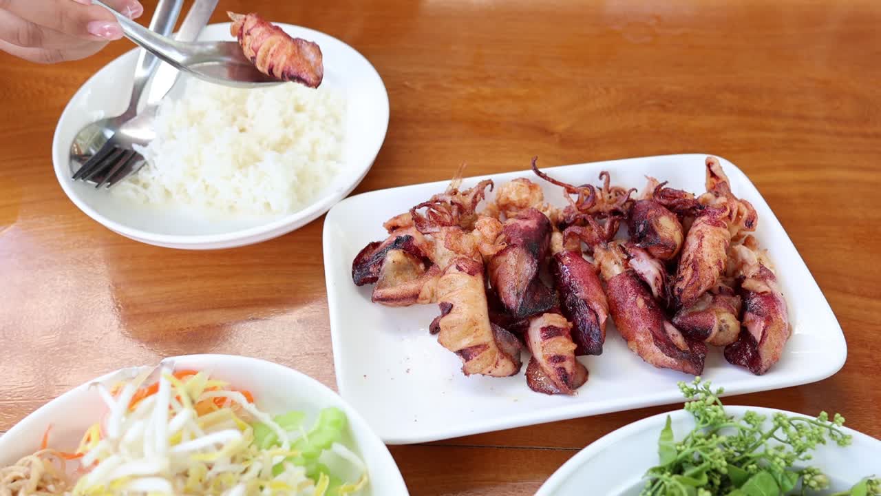 มือกำลังเสิร์ฟของอร่อยห่อเบคอนพร้อมเครื่องเคียง