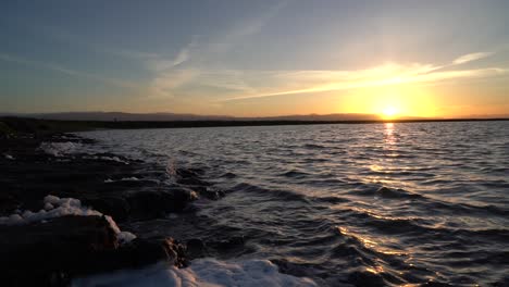 The-sun-setting-below-the-horizon-of-a-large-salt-pond-at-Alviso-Marina-County-Park-in-Mountain-View,-California