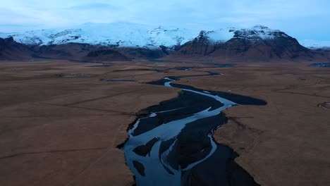 drone flyover at dusk in southern iceland with river and eyjafjallajökull in the background