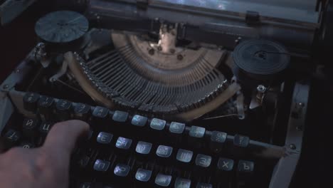 man prints with vintage soviet typewriter in the dark