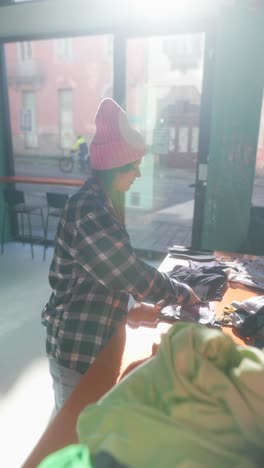 woman folding laundry in a laundromat