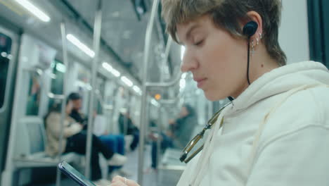 woman texting on mobile phone during metro ride