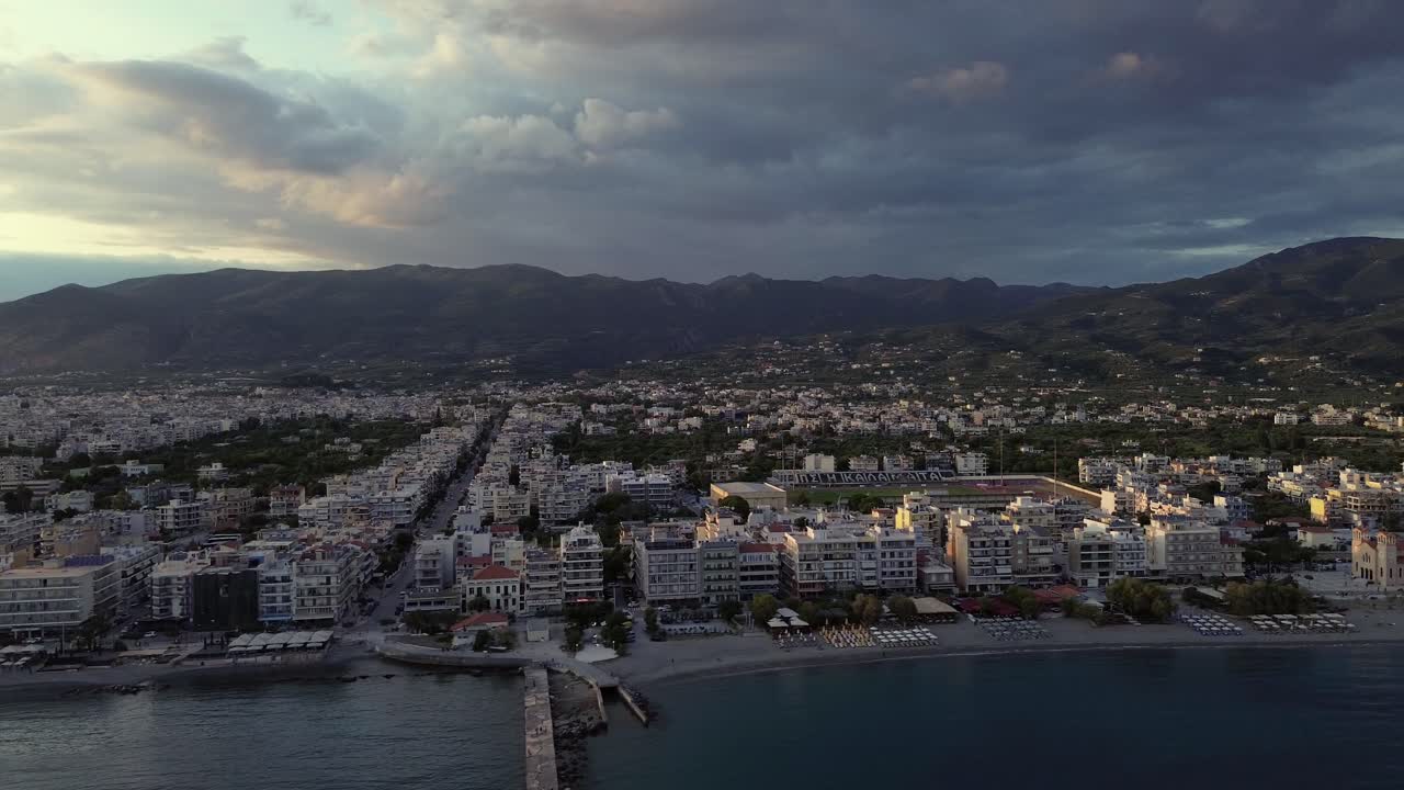 Vista aérea de ângulo alto da cidade de Kalamata numa tarde de primavera nublada, com movimento de câmera lateral para a esquerda, em 4K.