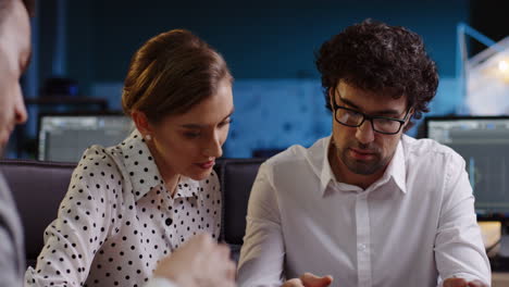 vista cercana del equipo de negocios sentado en la mesa y discutiendo sobre un proyecto en la oficina