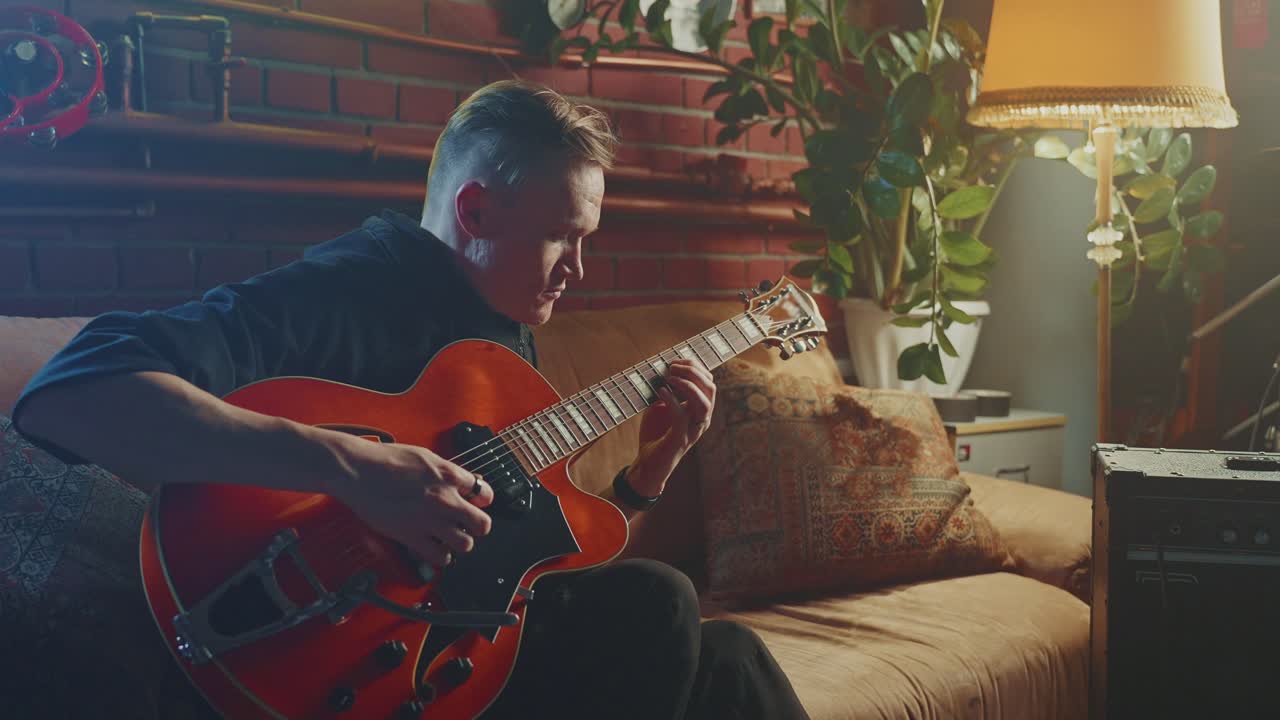 Man Playing Jazz Guitar at Home