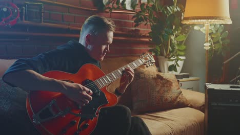 man playing jazz guitar at home